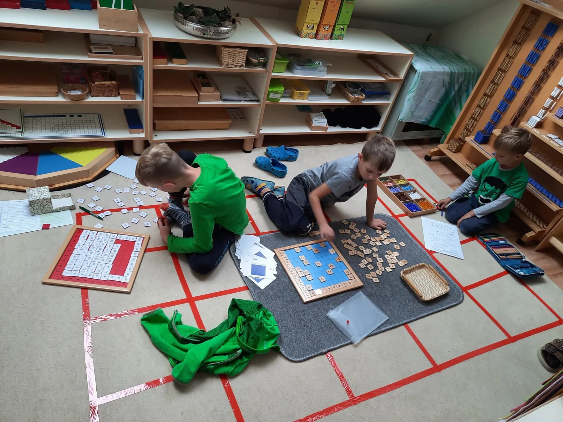 Připravené prostředí — dřevěné Montessori pomůcky srovnané na poličkách.